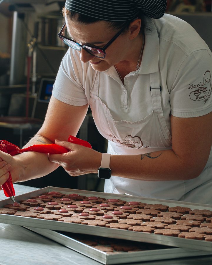 Una pasticcera farcisce gli stampi dei cioccolatini uno per uno