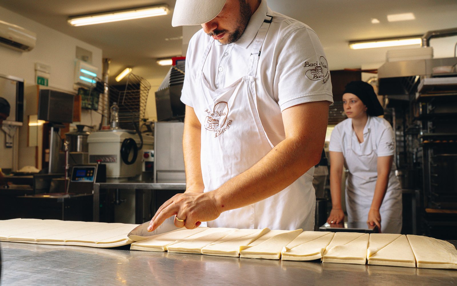 Il laboratorio al lavoro: la sfoglia viene tagliata a triangoli sul banco d’acciaio